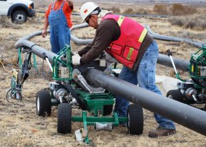 man in gray long sleeve shirt and orange vest riding on green and black tractor during