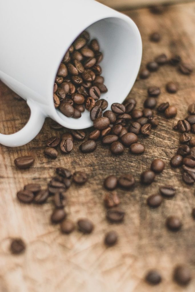 white ceramic mug on brown coffee beans